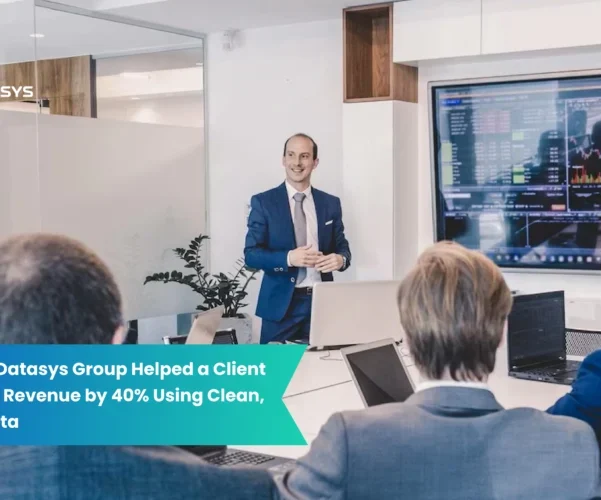 Business professional presenting data insights on a screen to a group of executives during a meeting. Overlay text highlights how Global Datasys Group helped a client increase revenue by 40% using clean, targeted data.
