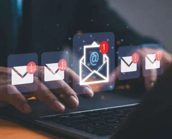 Professional using email marketing software with email icons and notification alerts, representing automated B2B campaigns by Global Datasys Group.