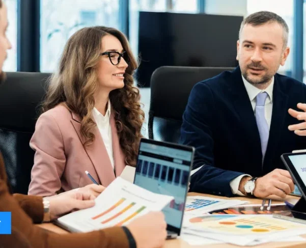 Business professionals in a meeting discussing growth strategies with charts, graphs, and laptops – Global Datasys Group, Your Growth Partner.